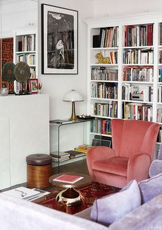 a living room filled with lots of books and furniture