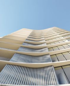 an upward view of a tall building with lots of windows