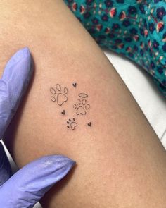 a woman's arm with a dog paw and hearts tattoo on the left thigh