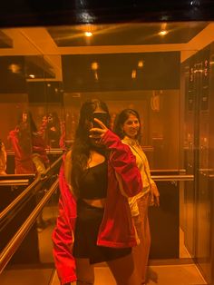 two women standing in front of a glass display case with their arms around each other