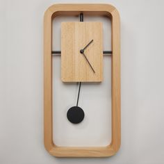 a clock made out of wood with a black pendulum on the front and back sides