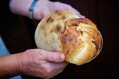 a person holding a piece of bread in their hand