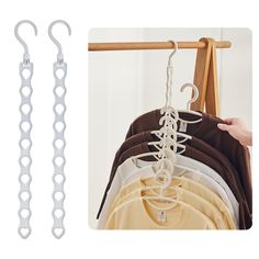 two white hangers are hanging on the clothes rack and one is holding several shirts