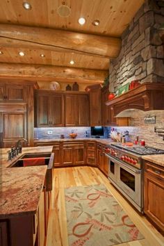 a large kitchen with wooden cabinets and granite counter tops, along with an area rug that matches the hardwood flooring