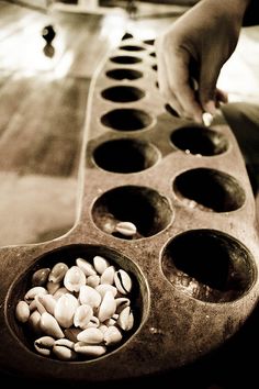 a person reaching for nuts in a metal pan