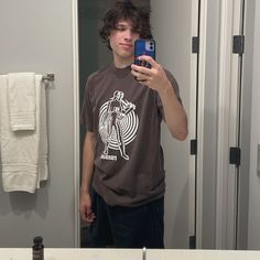 a young man is taking a selfie in the bathroom mirror with his cell phone