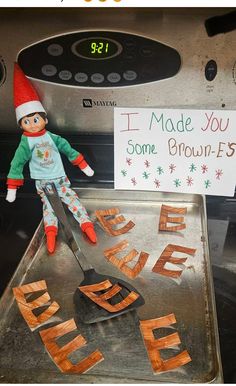 an elf is cooking some brown fries in the oven with a sign that says i made you some brown fries