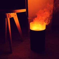 a lit candle sitting on top of a table next to a chair