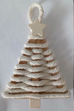 a white christmas tree made out of rope with a wooden star on it's top