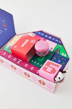 an open box with various items in it on a white surface and one is pink, the other is blue