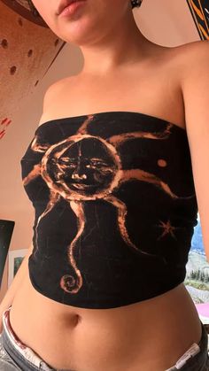 a woman wearing a black top with an image of a cat on it's chest