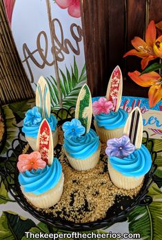 cupcakes with blue frosting and bunny ears are on a black platter