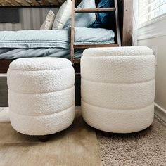 two white stools sitting on top of a carpeted floor