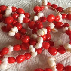 some red and white candy beads are on a tablecloth with a piece of string