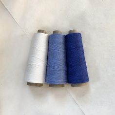 three spools of thread sitting next to each other on top of a table