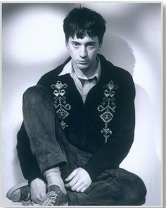 a young man sitting on the floor with his legs crossed