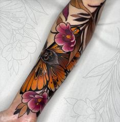 a butterfly and flowers tattoo on the arm