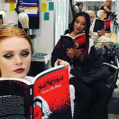 two women sitting in a salon reading books