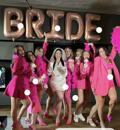 a group of women standing next to each other in front of a sign that says bride