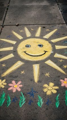 the sidewalk has been painted with chalk and is decorated with flowers, sun and stars