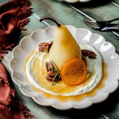 a white plate topped with a pear and whipped cream