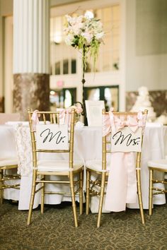 the chairs are decorated with pink sashes and mr and mrs signs