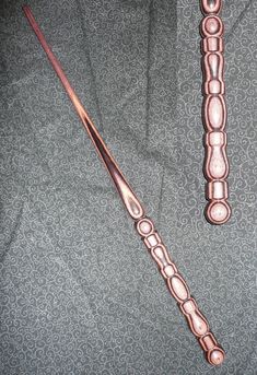 two metal objects sitting on top of a gray cloth covered floor next to each other