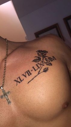 a shirtless man with a cross tattoo on his chest and name written in roman numerals