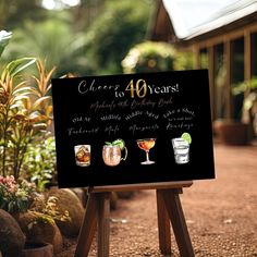 a sign that says cheers to 40 years with four different drinks in glasses on it