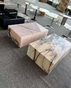 three marble tables sitting on top of a carpeted floor