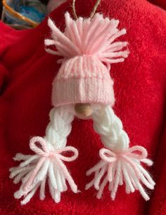 a knitted hat and scarf hanging from a hook on a red towel with other items in the background