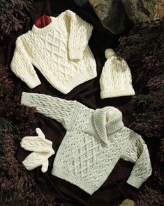 two knitted sweaters and one hat are shown in the knitting book, which is written