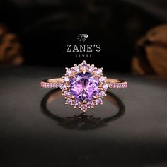 Description: Indulge in the enchanting beauty of our Rose Gold Round-Cut Amethyst Ring, featuring a stunning 1.5ct round-cut amethyst gemstone as the centerpiece.  The exquisite main gemstone is surrounded by a halo of complementary amethyst stones, creating a captivating aura of elegance and sophistication. Adorning the band are rows of shimmering amethyst gemstones, adding a touch of allure and refinement to the design.  We recommend selecting the rose gold color option to enhance the enchanti Rose Gold Amethyst Rings With Halo Setting, Rose Gold Amethyst Ring With Halo Setting, Rose Gold Amethyst Jewelry With Halo Setting, Rose Gold Amethyst Ring With Center Stone, Rose Gold Amethyst Ring With Halo Setting For Anniversary, Rose Gold Amethyst Ring With Halo Setting For Promise, Rose Gold Amethyst Ring With Accent Stones, Rose Gold Amethyst Ring With Round Cut, Bezel Diamond Ring