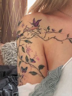 a woman's shoulder with flowers and butterflies on it