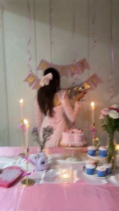 a woman sitting at a table with a cake and candles