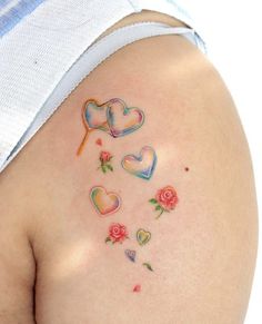 a woman's stomach with hearts and flowers painted on the back of her breast