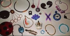 there are many different types of jewelry on the table, including ladybug ear rings and necklaces