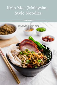 a bowl filled with noodles, meat and vegetables next to chopsticks on a table