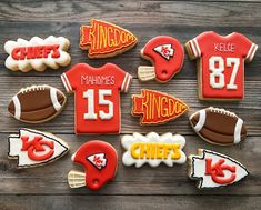 decorated cookies are arranged in the shape of footballs and jerseys on a wooden table