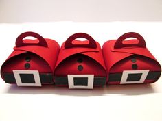 three red boxes with black and white designs on the top, one is shaped like a santa clause hat