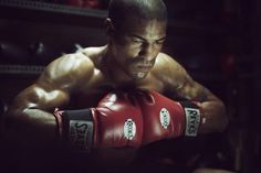 a man wearing red boxing gloves in a gym