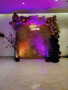 a purple and gold wedding backdrop with flowers