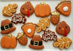 decorated cookies in the shape of turkeys, pumpkins and leaves on a white platter