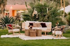 an outdoor seating area with wicker furniture and palm trees in the backgroud