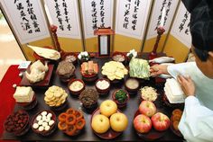 a woman standing in front of a table filled with different types of food on it