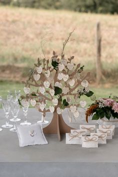 the table is set up with place cards and vases