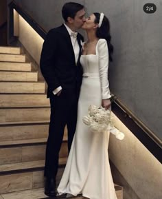 a bride and groom kissing on the stairs