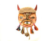 "This is a handmade ceramic mask. It's inspired by the traditions in our country, Bulgaria, but presented in a unique and original way. The day of the holiday is different for each individual village. It dates back to ancient times when people would put different devilish costumes and go around the houses to chase away the evil spirits. According to the belief when you put a mask like that in your home it will do the same thing - chase away the evil spirits. The mask is made of porcelain then gl Handmade Traditional Mask, Mask Sculpture, Ceramic Mask, Art Mask, Cotton Decor, Wall Mask, Evil Spirits, Ancient Times, A Mask