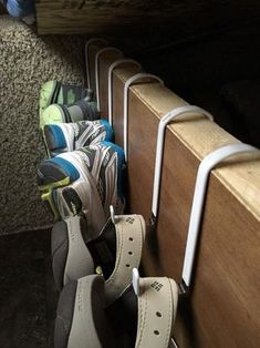 several pairs of tennis shoes are lined up against the wall