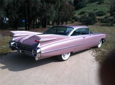 a pink car parked on the side of a road